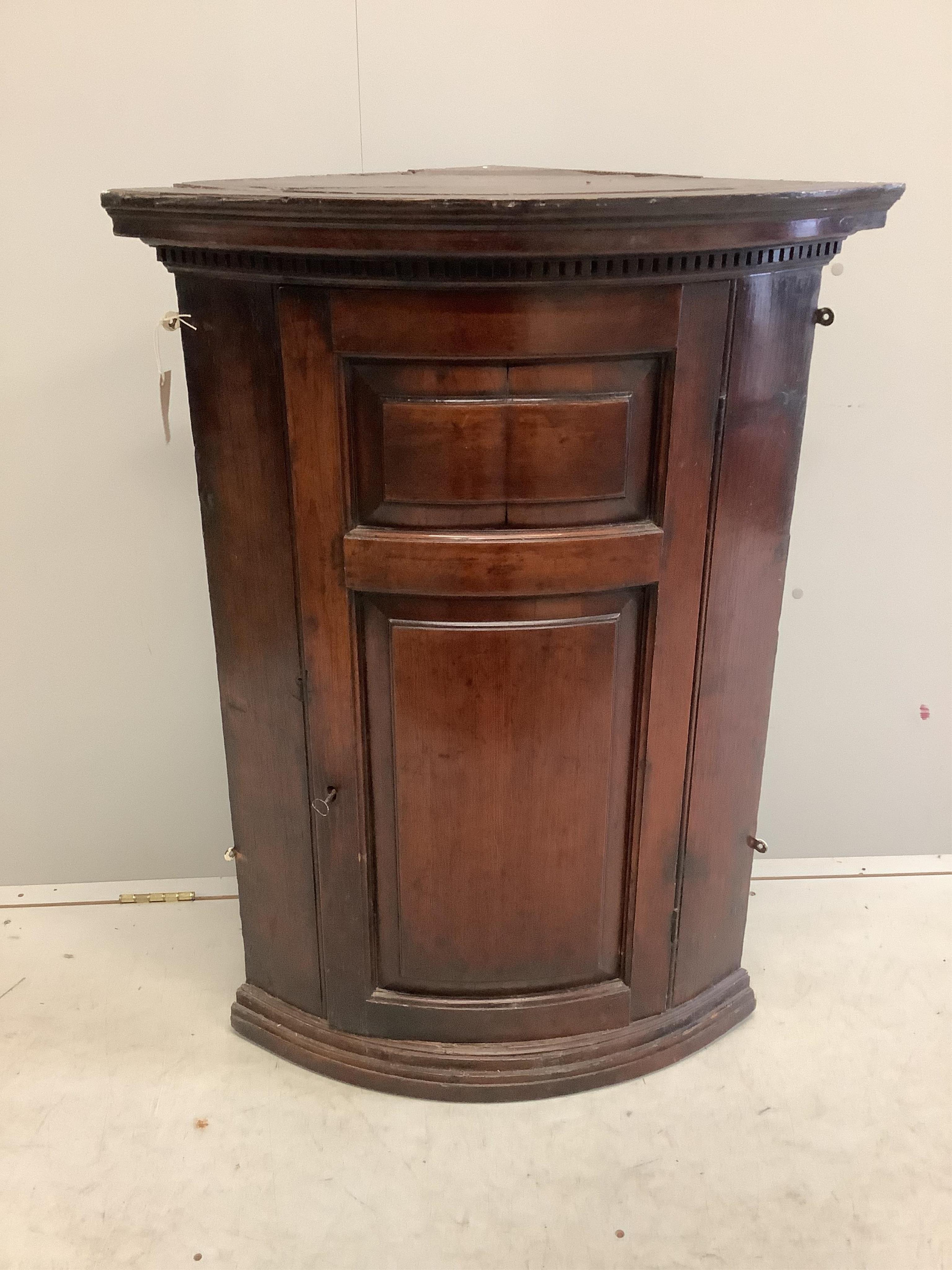 An 18th century pine bow front hanging corner cupboard, width 72cm, depth 46cm, height 101cm. Condition - fair to good